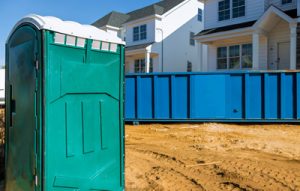 porta potty next to a dumpster on a construction site