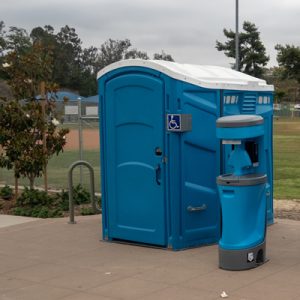 wheelchair accessible porta potty near a baseball field